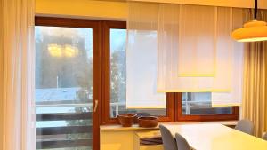 a dining room with a table and a window at Ferienwohnung Schöntal in Ludwigswinkel +5 photos