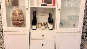 a white cabinet with bottles of wine in it at Ferienwohnung Schöntal in Ludwigswinkel