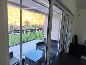 a sliding glass door with a chair on a balcony at Apartmani Gradac in Valjevo