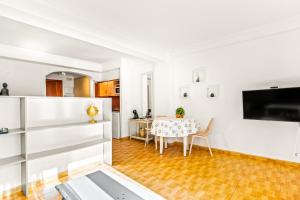a kitchen and dining room with white walls and a table at Unique Apartahotel 4-2 in Torrevieja