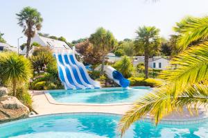 a pool with a water slide in a resort at Résidence des Saules in La Forêt-Fouesnant