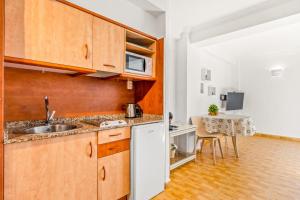 a kitchen with a sink and a table at Unique Apartahotel 4-2 in Torrevieja