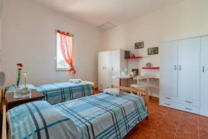 a bedroom with two beds and a table and a desk at Il Giglio Rosa in Sorso