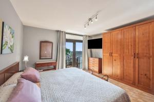 a bedroom with a large bed and a television at Casa Carolina Y Roger Tazacorte in Tazacorte