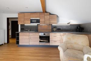 a kitchen with wooden cabinets and a chair in a room at Haus am See - Wohnung Jenner in Schönau am Königssee