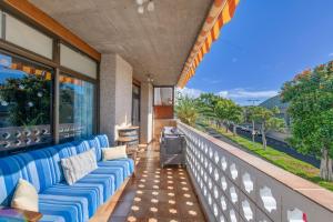 a blue couch on a balcony with a view of the ocean at Casa Carolina Y Roger Tazacorte in Tazacorte
