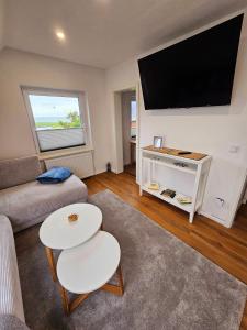 a living room with a large flat screen tv on the wall at Hus Matje in Langeneß