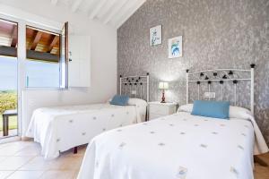 a bedroom with two beds and a window at Las Candelas - Las Sopeñas in Oreña