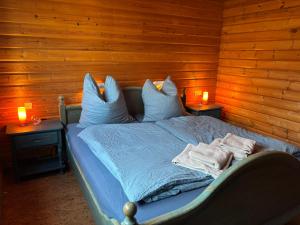 a bedroom with a bed with two candles on two tables at Chalet am Silbersee in Frielendorf