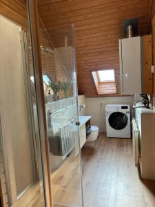 a bathroom with a sink and a washing machine at Chalet am Silbersee in Frielendorf +37 photos