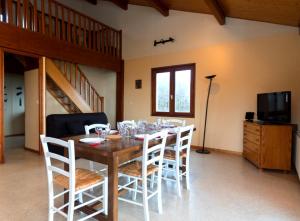 a dining room with a wooden table and white chairs at Gîte Télégraphe, Sonnay in Sonnay +6 photos