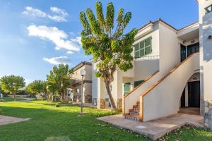 a house with a staircase and a palm tree at Tranquilo apto con preciosa cala in Cala en Forcat