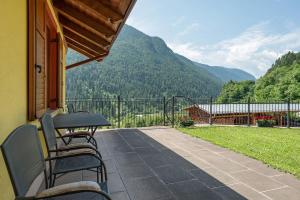 a patio with a table and chairs on a balcony at Agritur Sotto il Melo in Caldes