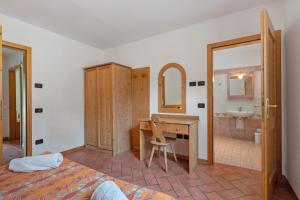 a bedroom with a desk and a bathroom with a sink at Agritur Sotto il Melo in Caldes +171 photos