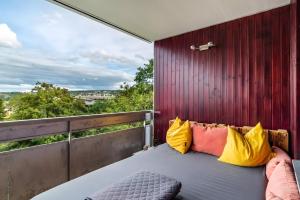 a bed with yellow and orange pillows on a balcony at Ferienwohnung Goldstadtblick in Pforzheim