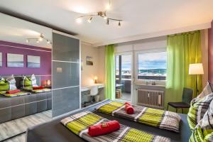 two beds in a room with green curtains and a desk at Ferienwohnung Goldstadtblick in Pforzheim