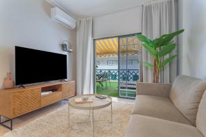 a living room with a tv and a couch and a table at Apartamento Luminoso Con Terraza in Puerto de la Cruz