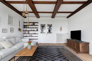 a living room with a couch and a tv at Sophienhof in Kronprinzenkoog