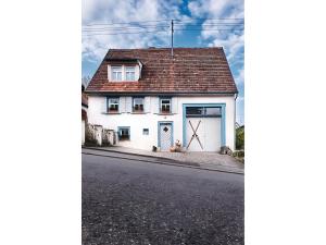 a white house with a garage on a street at Ferienhaus Lilace in Böttingen