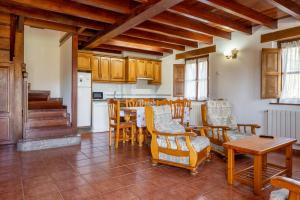 a living room with a table and chairs and a kitchen at Casa Collado Santo Tomás in El Collado