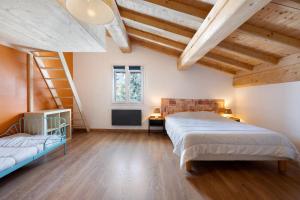 two beds in a room with wooden ceilings at Chalet Aussois Lerovi in Aussois