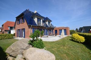 a brick house with a blue roof at Haus Boddenperle in Breege