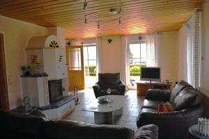 a living room with leather furniture and a tv at Haus Boddenperle in Breege