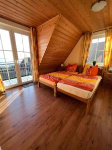 a bedroom with a bed in a wooden room with windows at Haus Boddenperle in Breege