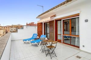 a balcony with blue chairs and a table on a building at Loft El Til-ler in Bellvei del Penedes