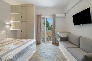 a living room with a couch and a tv at Ariston House in Porto Heli