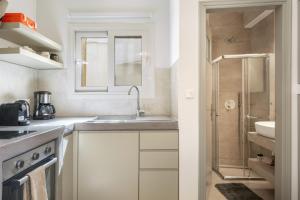 a white kitchen with a sink and a shower at Ariston House in Porto Heli +36 photos