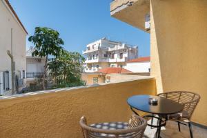 a patio with a table and chairs on a balcony at Ariston House in Porto Heli