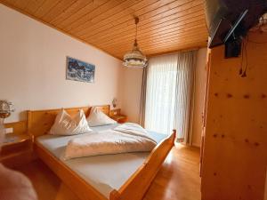 a bedroom with a bed with white sheets and a window at Die Kromarin in Kleinsölk