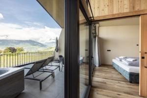 a bedroom with a bed and a balcony with a view at Apartment Oberhaslerhof in Schenna +66 photos