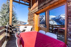 a table on a balcony with a view of mountains at L'Alpazen Jouve Duplex in Saint-Véran +15 photos