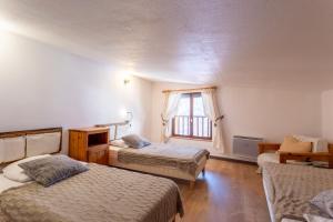 a bedroom with two beds and a window at L'Alpazen Jouve Duplex in Saint-Véran
