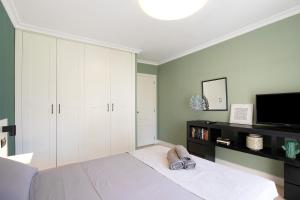 a bedroom with a white bed and a tv at Costa Bella la Tejita in La Tejita +17 photos