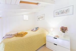 a bedroom with a yellow bed and a white dresser at Casa Das Batatas in Odeceixe