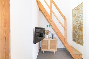 a tv sitting on a stand next to a wall at Casa Das Batatas in Odeceixe