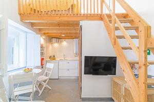 a small kitchen and dining room with a loft conversion with a staircase at Casa Das Batatas in Odeceixe