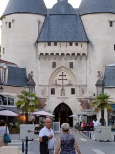 two people standing in front of a large building at Gîte avec bar et four à pizza in Étreval