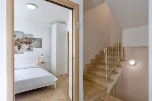 a hallway with a stairway with a bed and a mirror at L'angolo Porto Torres in Porto Torres