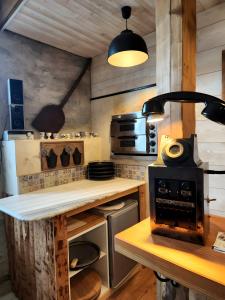 a kitchen with a stove and a counter top at Gîte avec bar et four à pizza in Étreval +21 photos