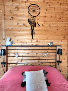 a bedroom with a wooden wall with a bicycle on the wall at Gîte avec bar et four à pizza in Étreval