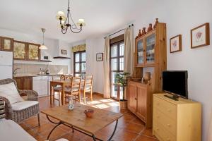 a kitchen and living room with a table and a tv at Cobijadas75 Segur in Vejer de la Frontera +16 photos