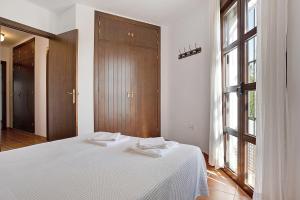 a bedroom with a white bed and a large window at Cobijadas75 Segur in Vejer de la Frontera