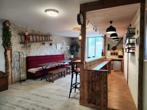 a kitchen and a dining room with a table and a counter at Gîte avec bar et four à pizza in Étreval
