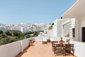 a balcony with tables and chairs and a view of a city at Cobijadas75 Segur in Vejer de la Frontera