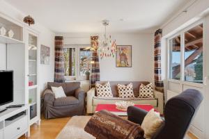 a living room with two couches and a tv at Ferienwohnung Christa in Sankt Märgen