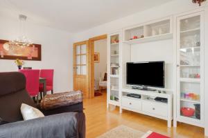 a living room with a white entertainment center with a television at Ferienwohnung Christa in Sankt Märgen